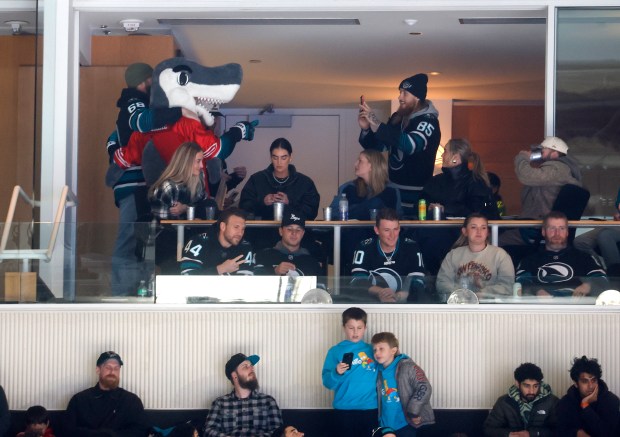 San Francisco 49ers' George Kittle (85) takes a photo of the San Jose Sharks mascot SJ Sharkie along with his 49ers teammates during the Sharks game against the Calgary Flames in the second period at the SAP Center in San Jose, Calif., on Tuesday, Dec. 16, 2025. (Nhat V. Meyer/Bay Area News Group)