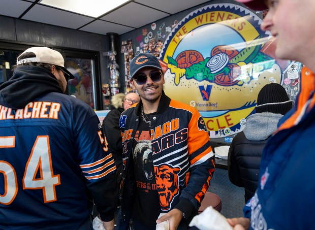 Bears fans pick up free hot dogs, Dec. 2, 2025, at The Wieners Circle in Chicago's Lincoln Park neighborhood after coach Ben Johnson took his shirt off in a postgame celebration for a win over the Eagles. (Brian Cassella/Chicago Tribune)