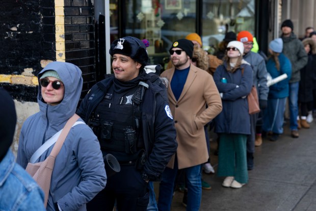 Chicago police Officer Richard Juarez Jr. lines up with Bears fans for free hot dogs, Dec. 2, 2025, at The Wieners Circle in Chicago's Lincoln Park neighborhood. (Brian Cassella/Chicago Tribune)