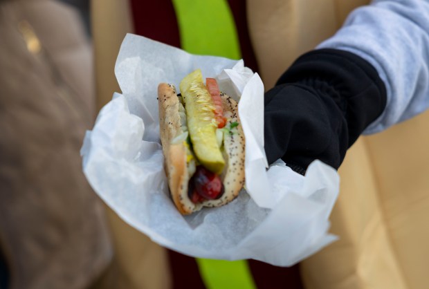 Bears fans pick up free hot Chicago dogs, Dec. 2, 2025, at The Wieners Circle in Chicago's Lincoln Park neighborhood. (Brian Cassella/Chicago Tribune)
