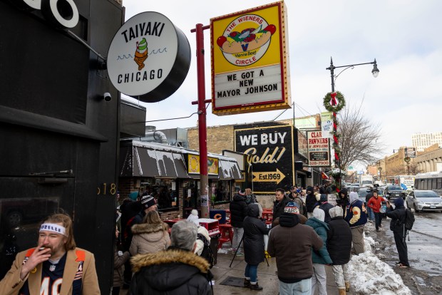 Bears fans line up for free hot dogs Tuesday, Dec. 2, 2025, at The Wieners Circle in Chicago's Lincoln Park neighborhood after coach Ben Johnson took his shirt off in a postgame celebration for a win over the Eagles. (Brian Cassella/Chicago Tribune)