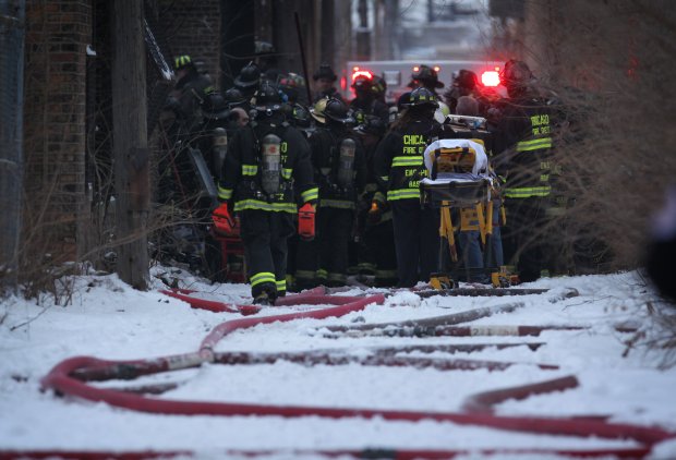 Chicago Fire personnel watch as rescuers dig for injured firefighters in the rear of a commercial building at the scene of a three-alarm fire at 1744 E. 75th St., Chicago on Dec. 22, 2010. (E. Jason Wambsgans/Chicago Tribune)