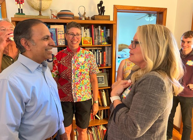Democratic U.S. Rep. Raja Krishnamoorthi of Schaumburg, left, speaks with Jackson County State's Attorney Marsha Cascio-Hale during a July 29, 2025, event for Krishnamoorthi's Democratic primary campaign for U.S. Senate at the Carbondale home of former Illinois Lt. Gov. Sheila Simon, center. (Brian Sapp/WSIU)