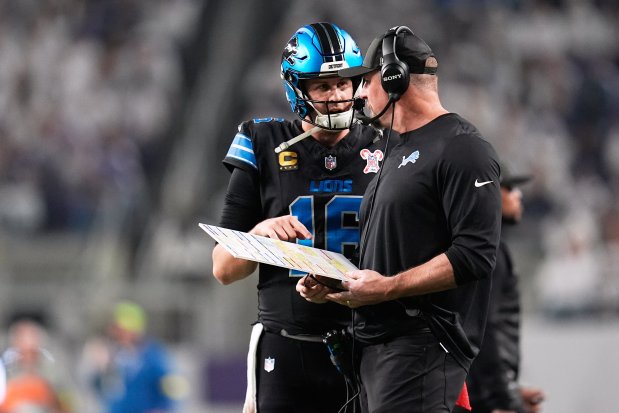 Lions quarterback Jared Goff, left, speaks with coach Dan Campbell during the first half of a game against the Vikings on Thursday, Dec. 25, 2025, in Minneapolis. The Lions lost 23-10 and were eliminated from playoff contention. (Abbie Parr/AP)