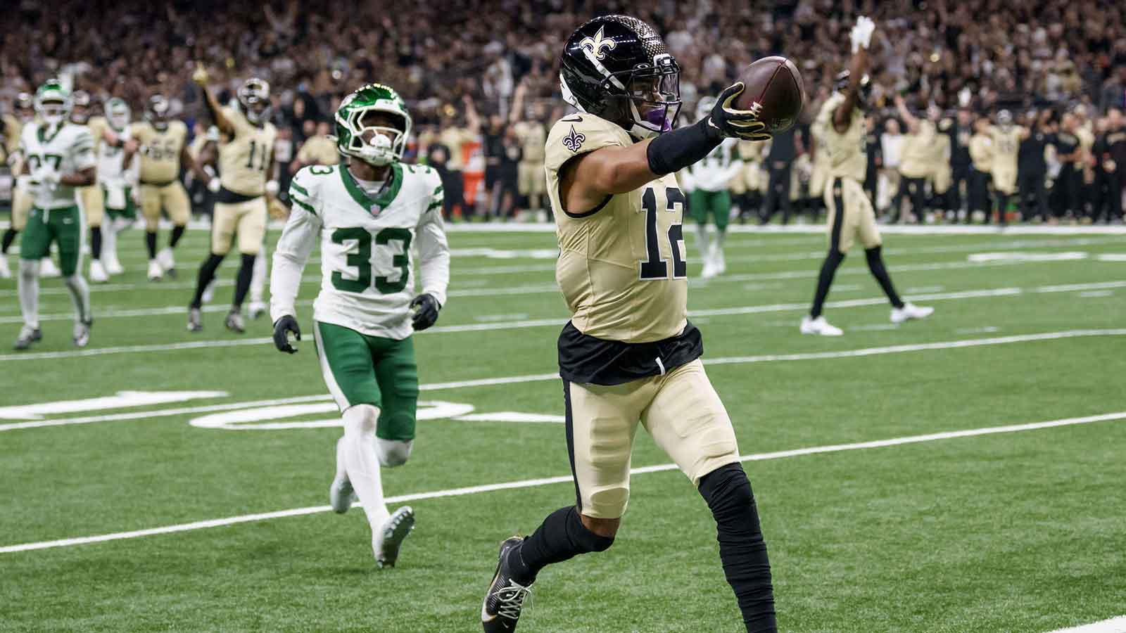 New Orleans Saints wide receiver Chris Olave (12) crosses the goal line for a touchdown against New York Jets cornerback Jordan Clark (33) during the third quarter at Caesars Superdome.