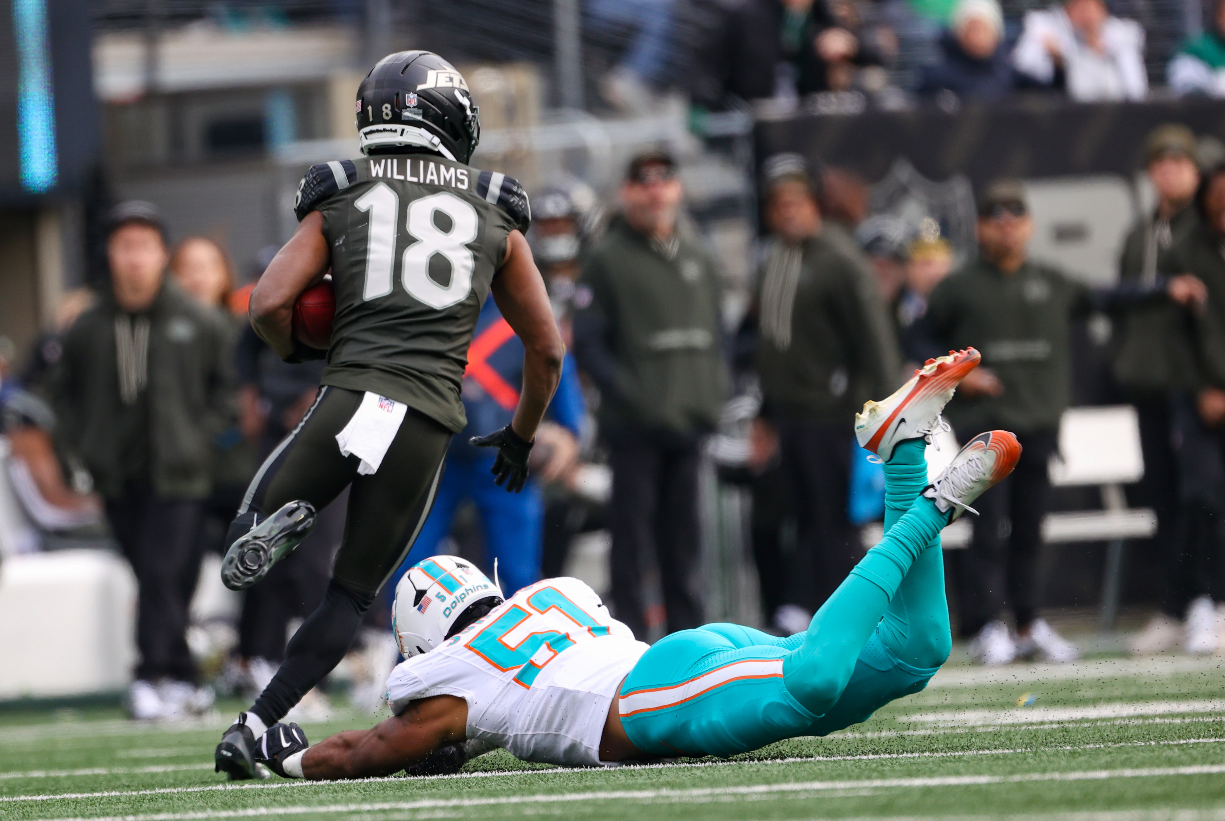 New York Jets return man Isaiah Williams (18) makes Miami Dolphins linebacker Caleb Johnson (51) miss and takes this punt to the house for a first half Jets touchdown, Sunday, Dec. 7, 2025 at MetLife Stadium in East Rutherford, N.J.