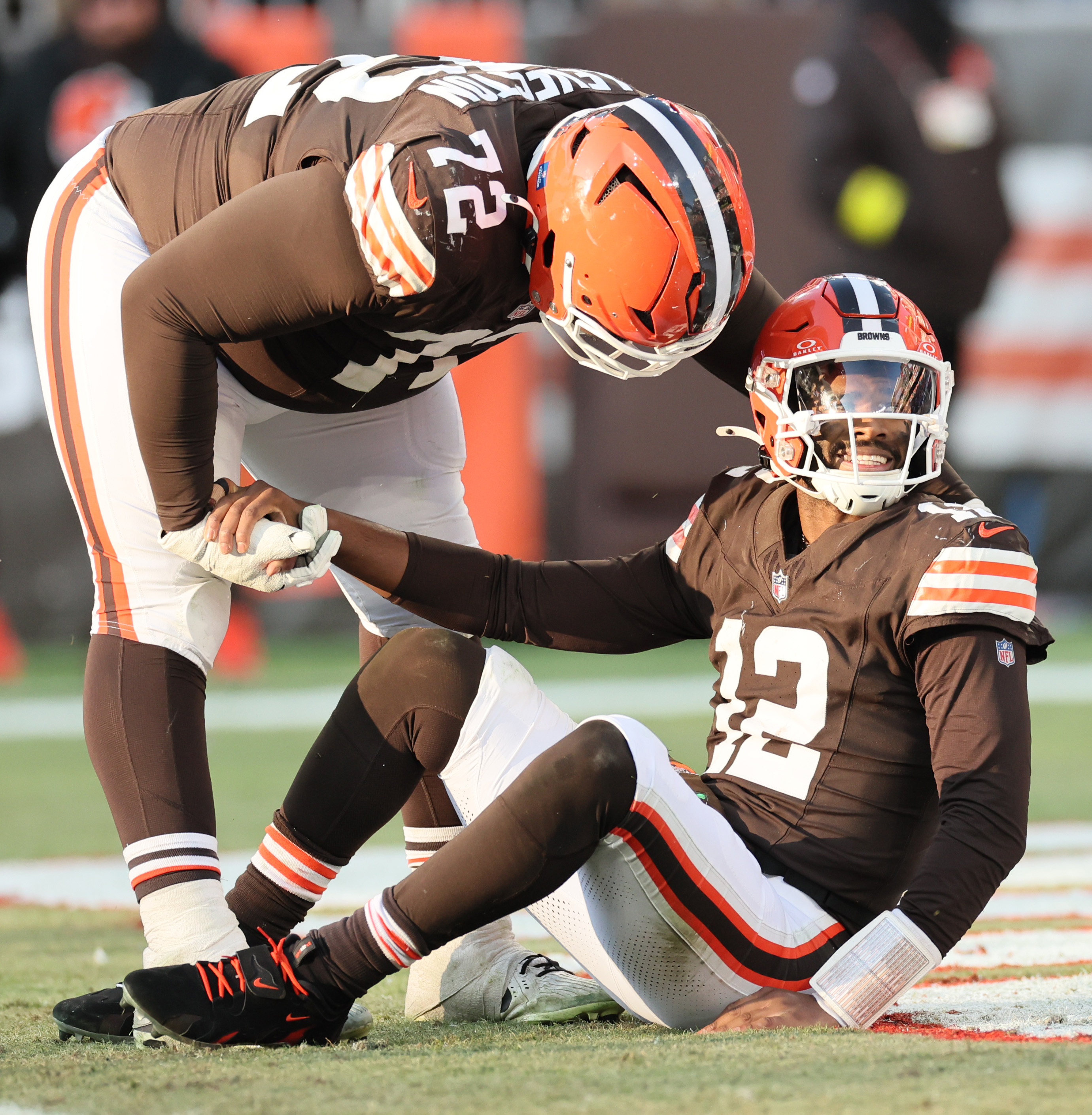 Buffalo Bills defensive tackle Phidarian Mathis helps Cleveland Browns quarterback Shedeur Sanders off the turf after Sanders was called for intentional grounding in the second half.  