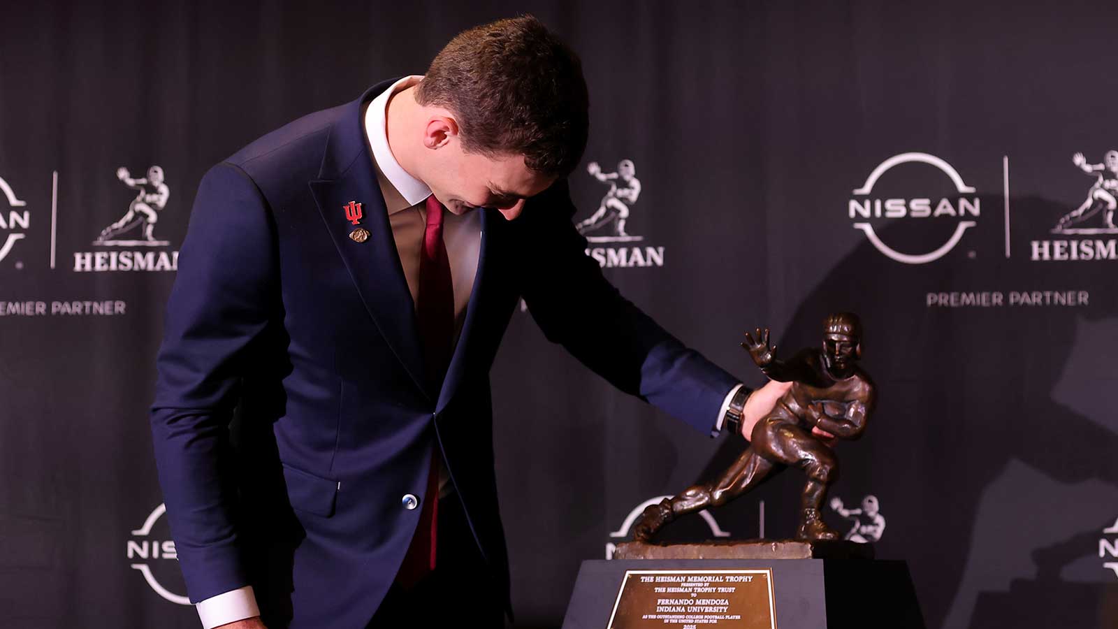 Indiana Hoosiers quarterback Fernando Mendoza looks at his name on the nameplate of the Heisman trophy during a press conference at the New York Marriott Marquis after winning the award. 