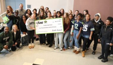 Franklin girls flag football team holding a large check for $4,000
