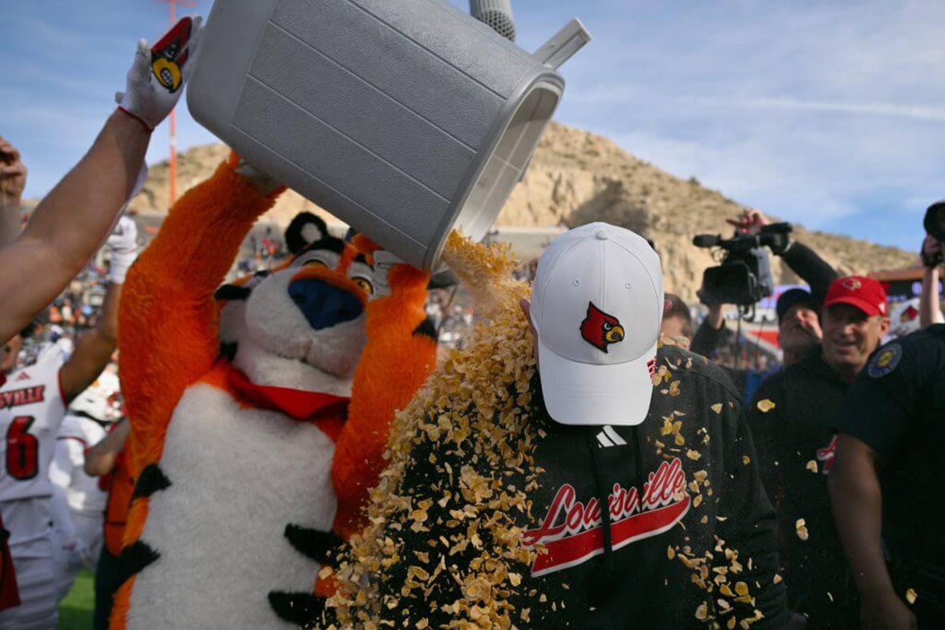 The Tony the Tiger mascot pours a bucket of Frosted Flakes on Louisville coach Jeff Brohm
