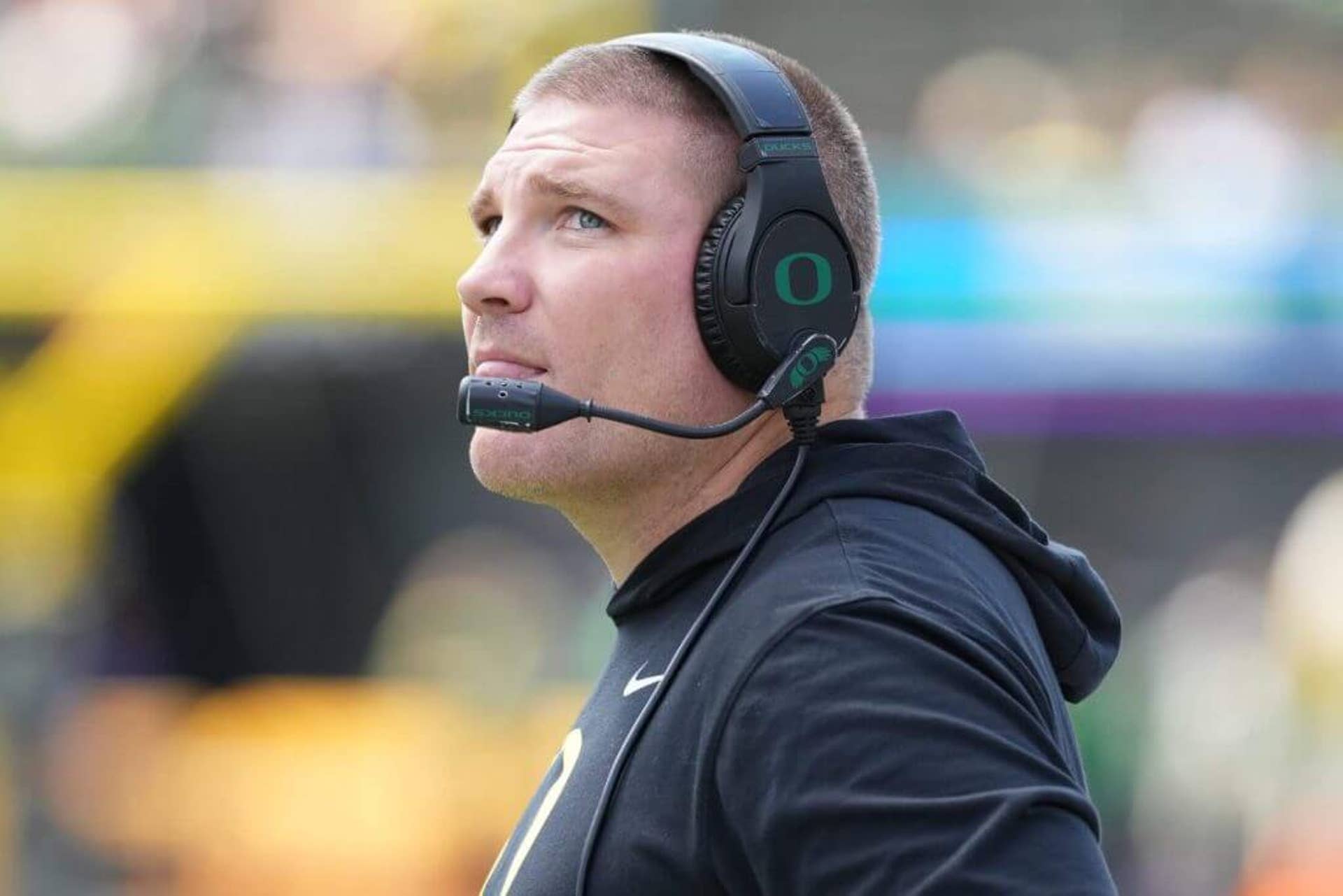 Oregon defensive coordinator Tosh Lupoi, wearing a headset, takes in the action on the field.