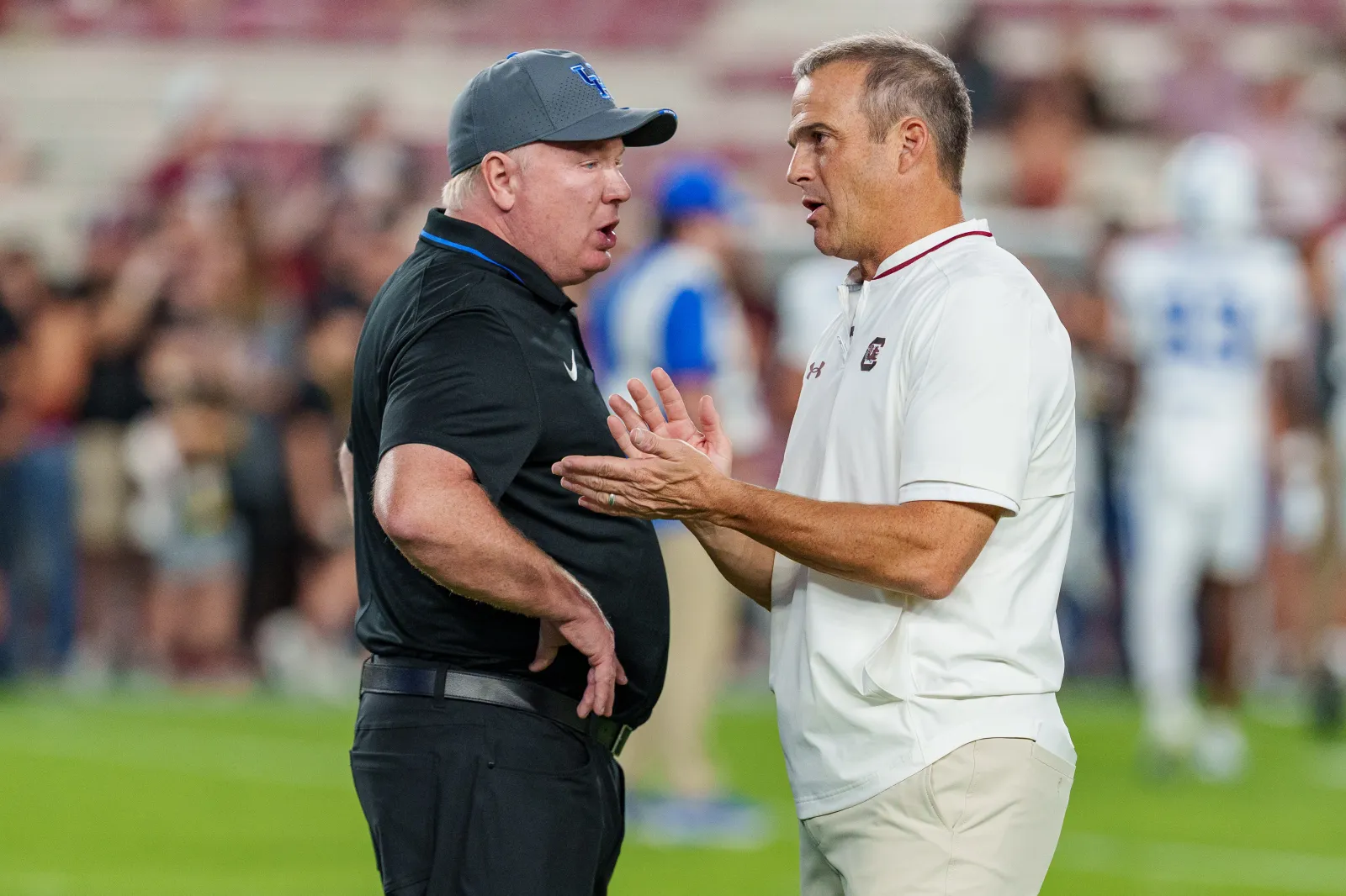 College football head coach Mark Stoops of the Kentucky Wildcats talks with head coach Shane Beamer of the South Carolina Gamecocks