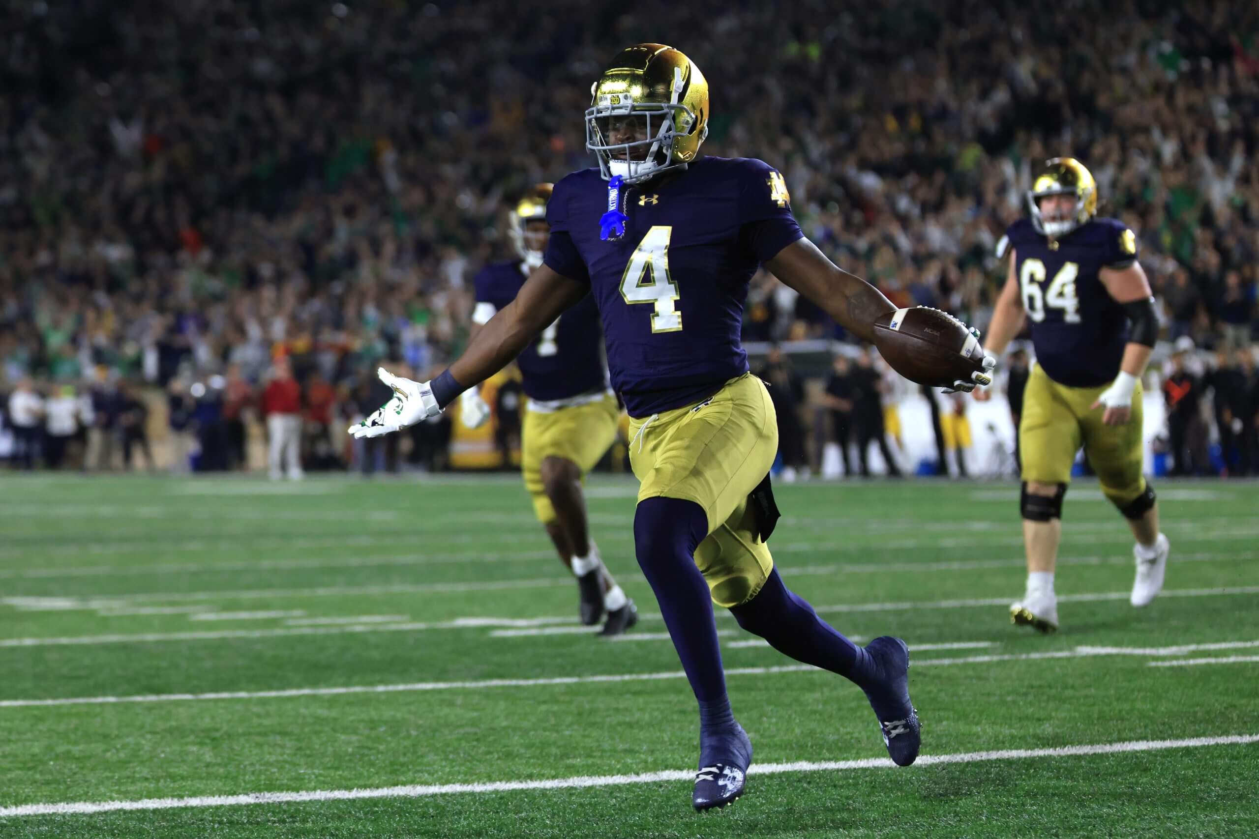 Jeremiyah Love celebrates with the ball in his hand.