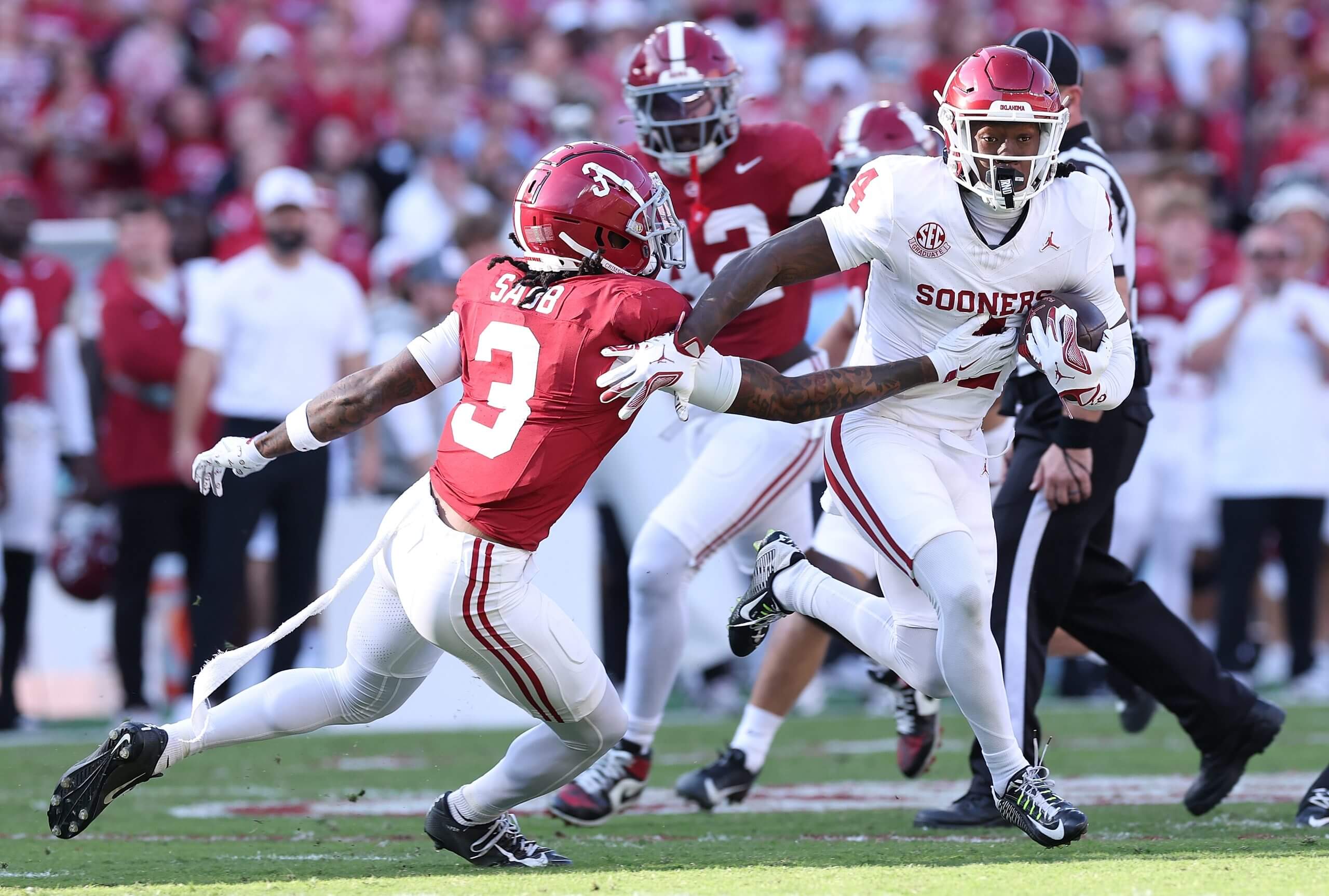 Oklahoma's Deion Burks runs with the ball while Keon Sabbs grabs him.