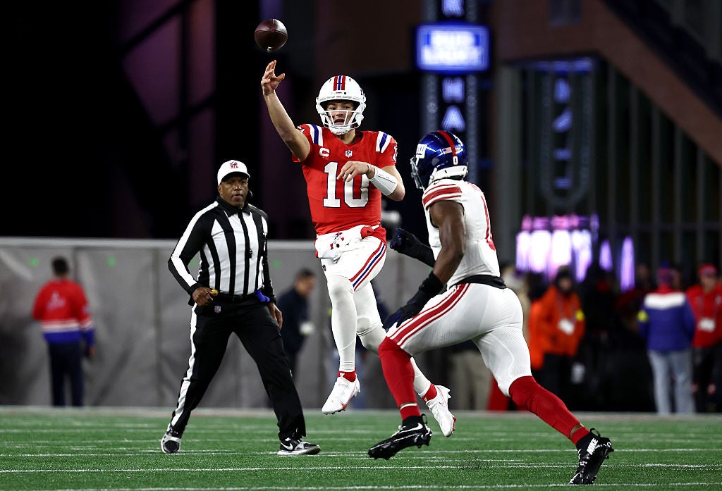 FOXBOROUGH, MASSACHUSETTS - DECEMBER 01: Drake Maye #10 of the New England Patriots makes a pass while under pressure from Brian Burns #0 of the New York Giants during the second quarter of the game at Gillette Stadium on December 01, 2025 in Foxborough, Massachusetts. 