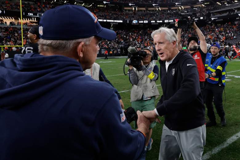 Raiders and Broncos coaches shake hands at midfield.