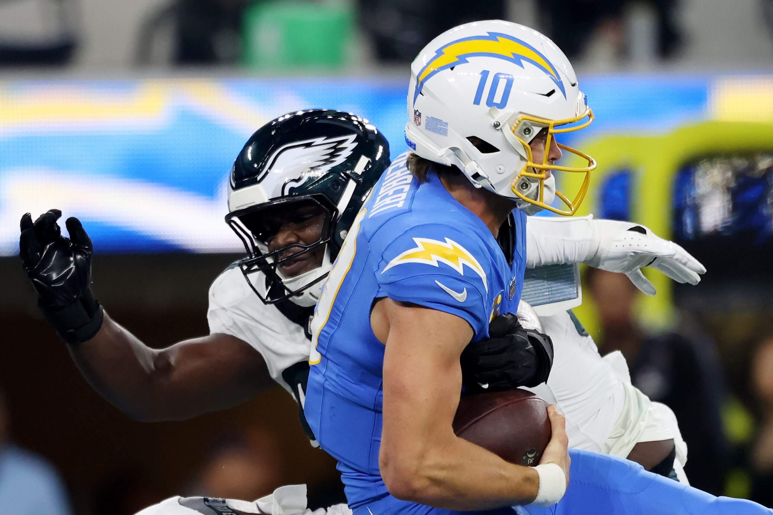 Jordan Davis of the Philadelphia Eagles, left, sacks Los Angeles Chargers quarterback Justin Herbert, right.