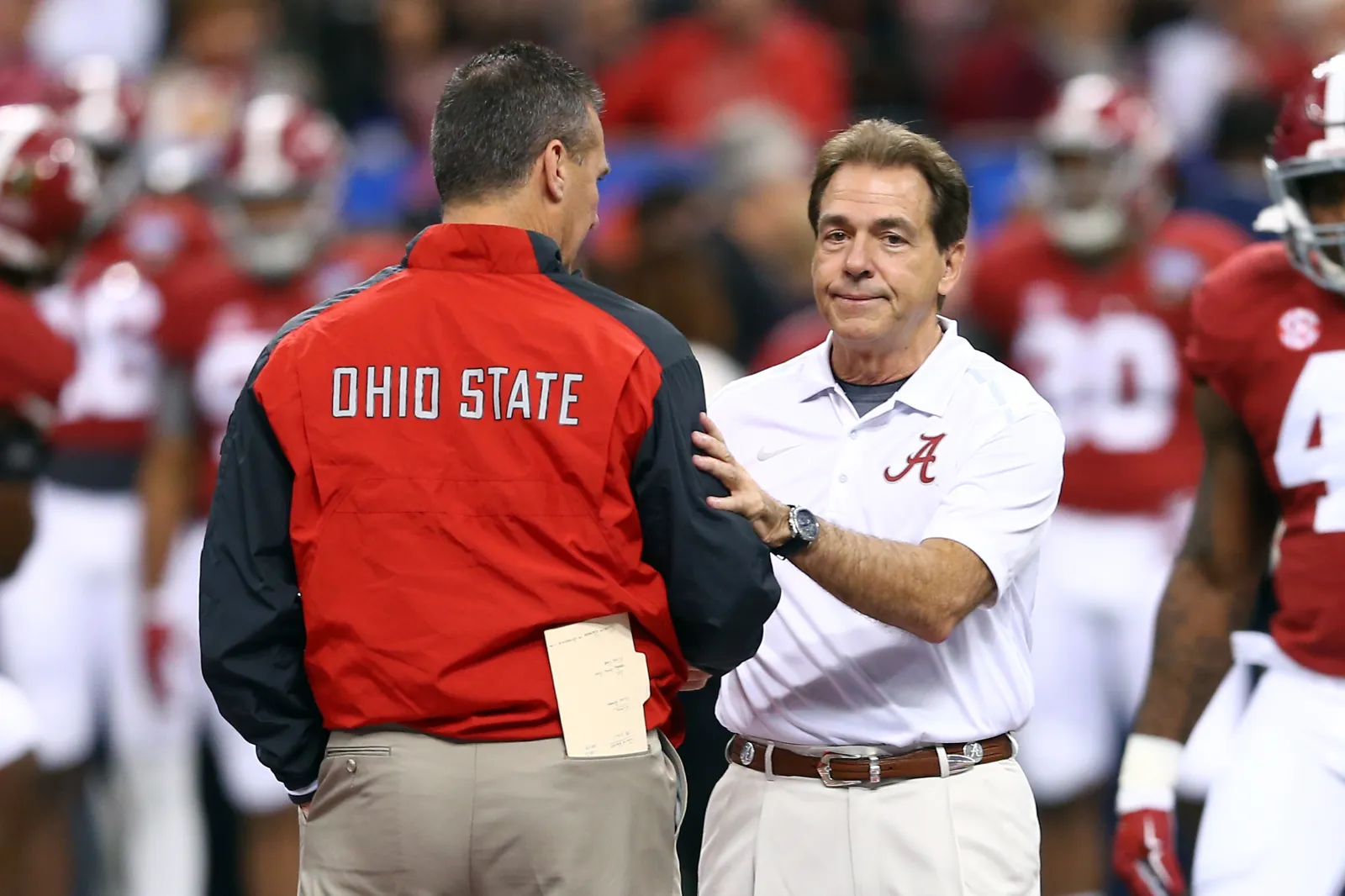 Former head coach Urban Meyer of the Ohio State Buckeyes shakes hands with former head coach Nick Saban of the Alabama Crimson Tide.