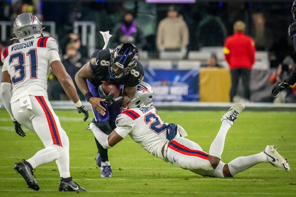 Baltimore Ravens quarterback Lamar Jackson (8) is hit by New England Patriots safety Jaylinn Hawkins (21) after a short gain in the 2nd quarter as the Baltimore Ravens host the New England Patriots at M&T Bank Stadium. The Patriots defeated the Ravens 28 - 24.