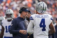 Dallas Cowboys head coach Brian Schottenheimer talks with quarterback Dak Prescott (4)...