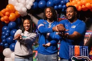 Defensive lineman Kevin “KJ” Ford Jr. helps his dad, Kevin Ford Sr., with his Gator Chomp...