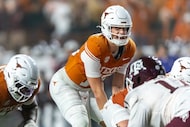 Texas quarterback Arch Manning, center, calls over the line during the second half of an...