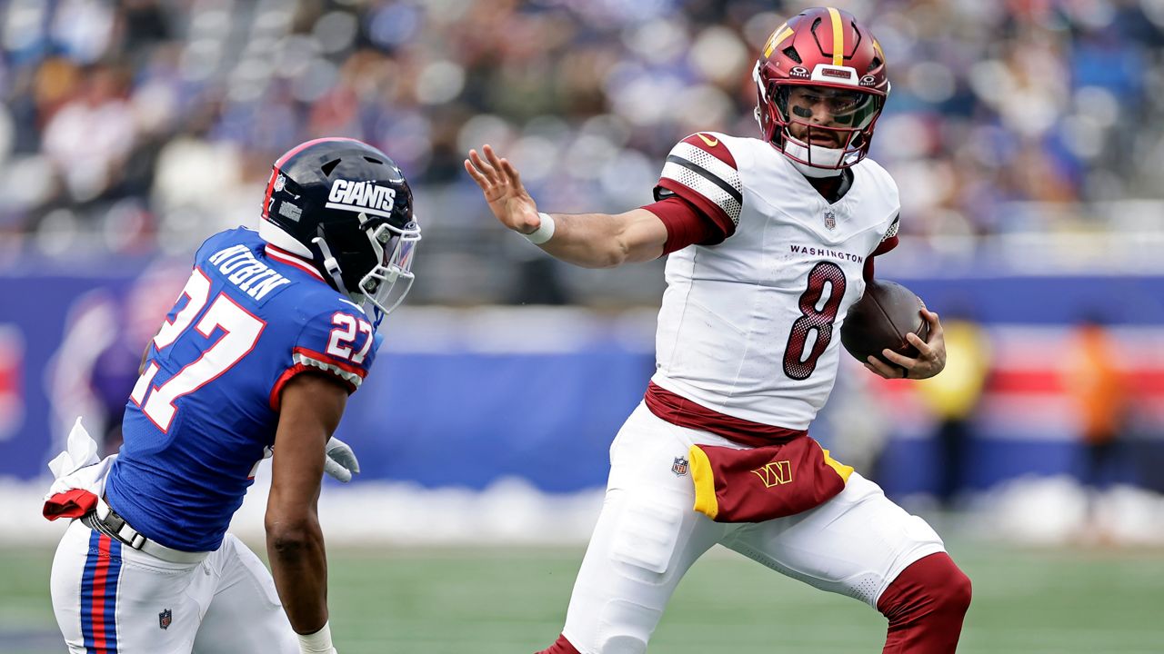 Washington Commanders quarterback Marcus Mariota ran with the ball against the New York Giants on Sunday in East Rutherford, N.J.