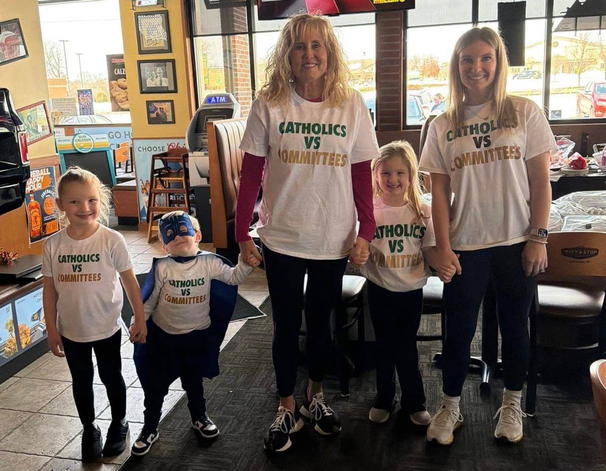 Katie Bell, her children and her mother model "Catholics vs. Committees" shirts she's selling to Notre Dame fans.