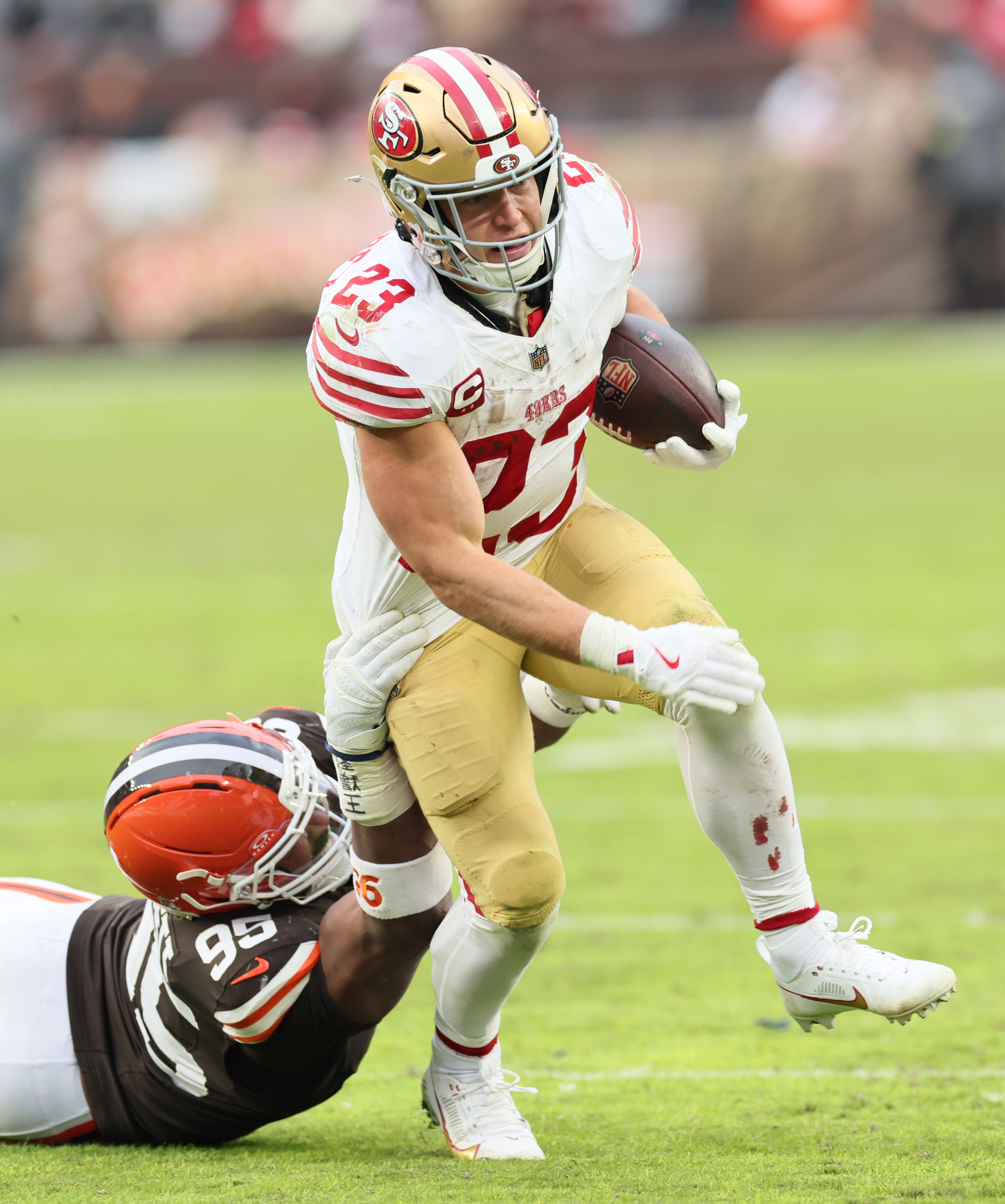 San Francisco 49ers running back Christian McCaffrey tries to elude the tackle attempt of Cleveland Browns defensive end Myles Garrett on a rush play in the second half at Huntington Bank Field.