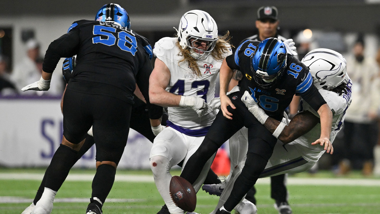 Detroit Lions quarterback Jared Goff (16) fumbles the ball defended by Minnesota Vikings linebacker Andrew van Ginkel (43) and linebacker Dallas Turner (15) in the fourth quarter at U.S. Bank Stadium.