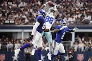 Dallas Cowboys wide receiver CeeDee Lamb (88) makes a leaping catch between New York Giants...