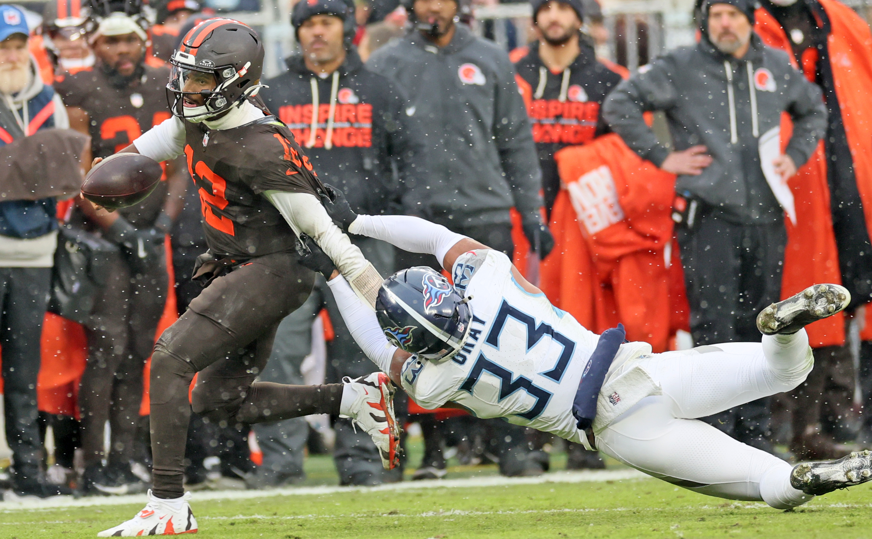 Tennessee Titans linebacker Cedric Gray tries to drag down Cleveland Browns quarterback Shedeur Sanders on a keeper in the first half at Huntington Bank Field.