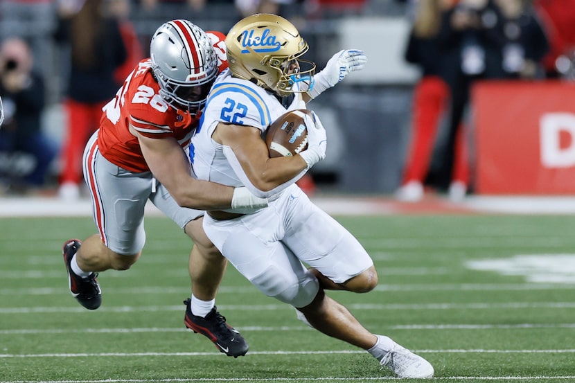 Ohio State linebacker Payton Pierce, left, tackles UCLA running back Anthony Frias, right,...