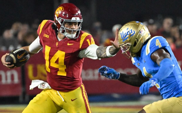Quarterback Jayden Maiava #14 of the USC Trojans strong arms defensive back Key Lawrence #4 of the UCLA Bruins in the second half of a NCAA football game at the Los Angeles Memorial Coliseum in Los Angeles on Saturday, November 29, 2025. (Photo by Keith Birmingham, Pasadena Star-News/ SCNG)