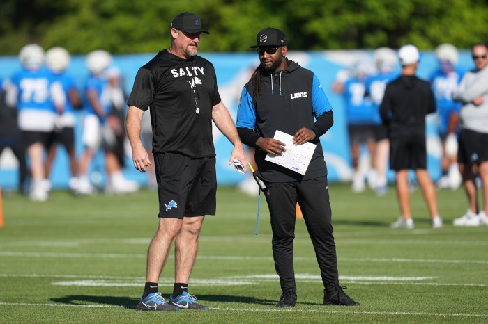 Dan Campbell, left, and defensive coordinator Kelvin Sheppard, right talk on the field.