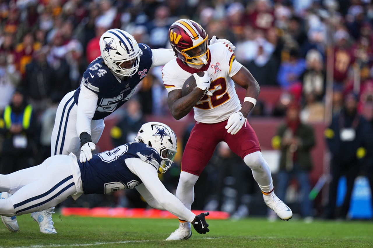 Washington Commanders running back Jacory Croskey-Merritt tries to get away from Dallas Cowboys defensive end Sam Williams during an NFL game on Thursday, Dec. 25, 2025, at Northwest Stadium in Landover, Md.