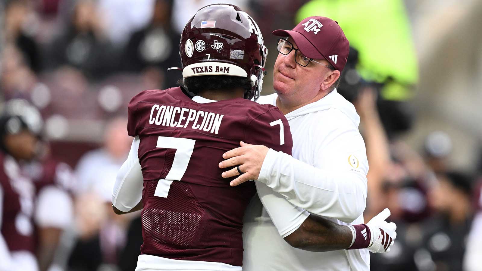 Texas A&M Aggies head coach Mike Elko hugs Texas A&M Aggies wide receiver KC Concepcion (7) prior to the game against the Miami Hurricanes during the first round of the CFP National Playoff at Kyle Field.