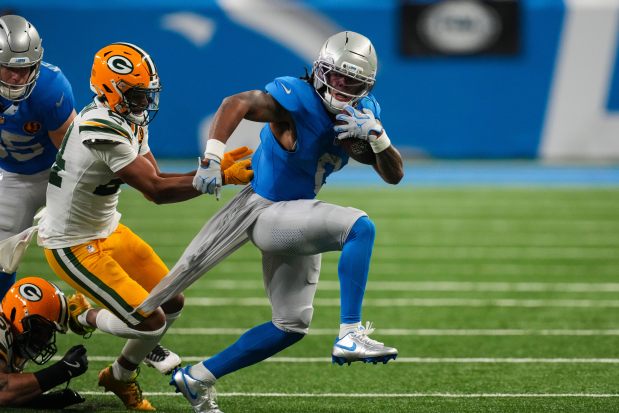 Detroit Lions running back Jahmyr Gibbs (0) pulls away from Green Bay Packers cornerback Carrington Valentine (24) during the first half an NFL football game in Detroit, Thursday, Nov. 27, 2025. (AP Photo/Paul Sancya)
