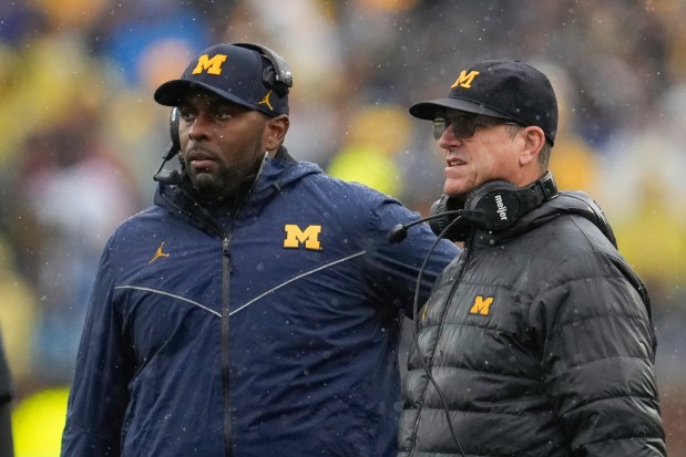 FILE - Michigan offensive coordinator Sherrone Moore, left, and coach Jim Harbaugh watch the team's play against Indiana during an NCAA college football game in Ann Arbor, Mich., Oct. 14, 2023. (AP Photo/Paul Sancya)