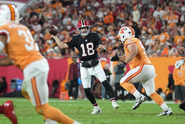 Atlanta Falcons quarterback Kirk Cousins (18) makes an off balanced pass during an NFL football game against the Tampa Bay Buccaneers, Thursday, Dec 11, 2025, in Tampa, Fla. (AP Photo/Peter Joneleit)