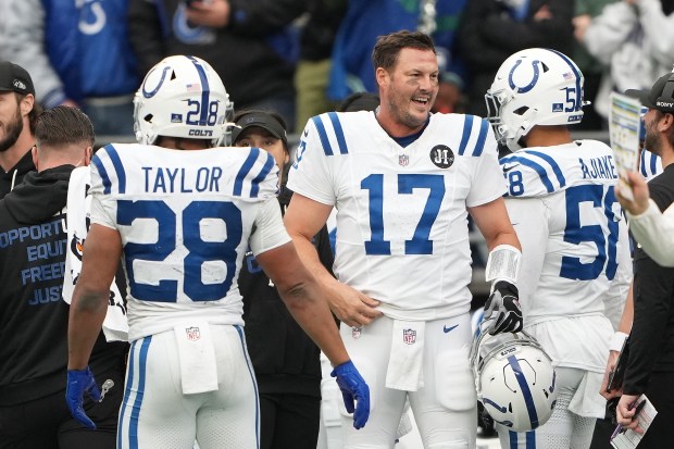 Indianapolis Colts quarterback Philip Rivers (17) smiles while greeting running back Jonathan Taylor (28) and linebacker Austin Ajiake (58) during an NFL football game against the Indianapolis Colts, Sunday, Dec. 14, 2025 in Seattle. (AP Photo/Lindsey Wasson)