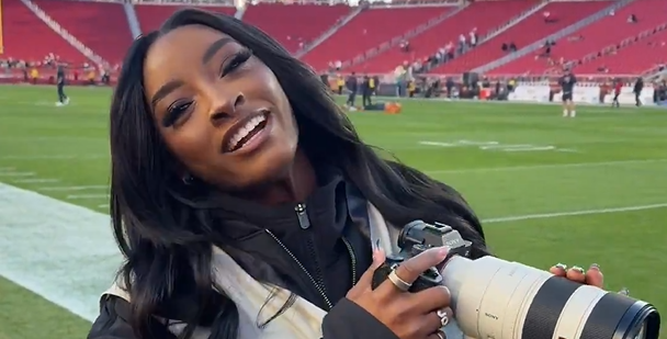 Simone Biles serves as photographer during Bears-49ers game