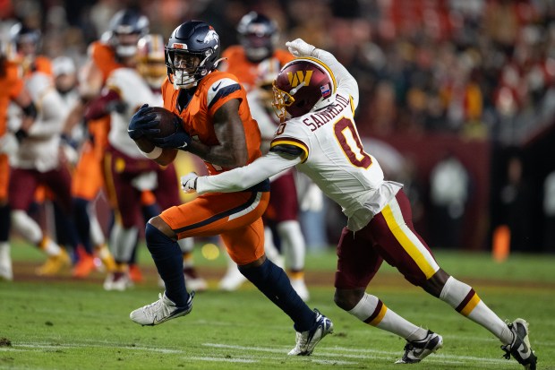 Wide receiver Courtland Sutton (14) of the Denver Broncos reels in a pass by quarterback Bo Nix (10) in front of cornerback Mike Sainristil (0) of the Washington Commanders on Sunday, Nov. 30, 2025, at Northwest Stadium in Landover, MD. (Photo by Timothy Hurst/The Denver Post)
