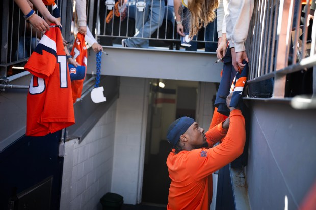 Running back RJ Harvey (12) of the Denver Broncos signs autographs for fans before a game against the Green Bay Packers on Sunday, Dec. 14, 2025, at Empower Field at Mile High Stadium in Denver. (Photo by Timothy Hurst/The Denver Post)