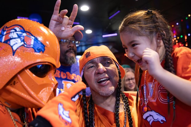 James Chavez, known as Orange Vader, left, interacts with Stormy Manuo-Villa, 4, as Nick Villa, 54, watches Andrew Young, The Mad Fanatic, perform at The Point Sports Bar and Grill in Thornton on Saturday, Nov. 15, 2025. (Photo by McKenzie Lange/Special to The Denver Post)