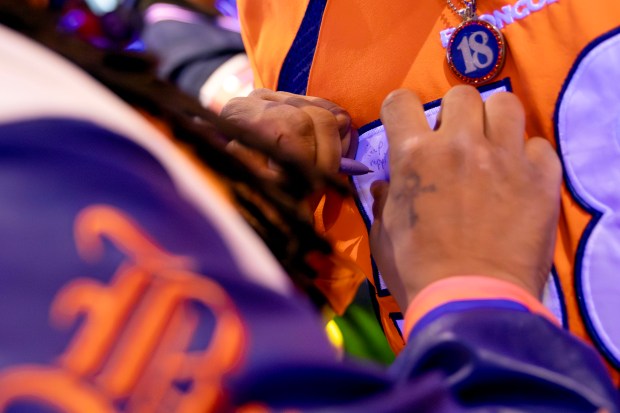 Andrew Young, known as Mad Fanatic, signs a fan's Bronco jersey before he performs rap songs about the Denver Broncos at The Point Sports Bar and Grill in Thornton, Colo., on Saturday, Nov. 15, 2025. Mad Fanatic, of Connecticut, founded the super-fan club Bronco Gang in 2013, now with members from around the world. (Photo by McKenzie Lange/Special to The Denver Post)