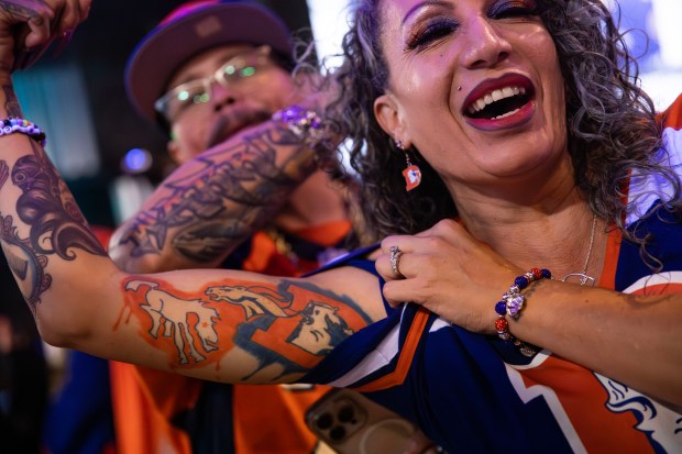 Cyndi Vigil, 48, shows off her commemorative Broncos Super Bowl 50 tattoo as Andrew Young, The Mad Fanatic, performs at The Point Sports Bar and Grill in Thornton on Saturday, Nov. 15, 2025. (Photo by McKenzie Lange/Special to The Denver Post)