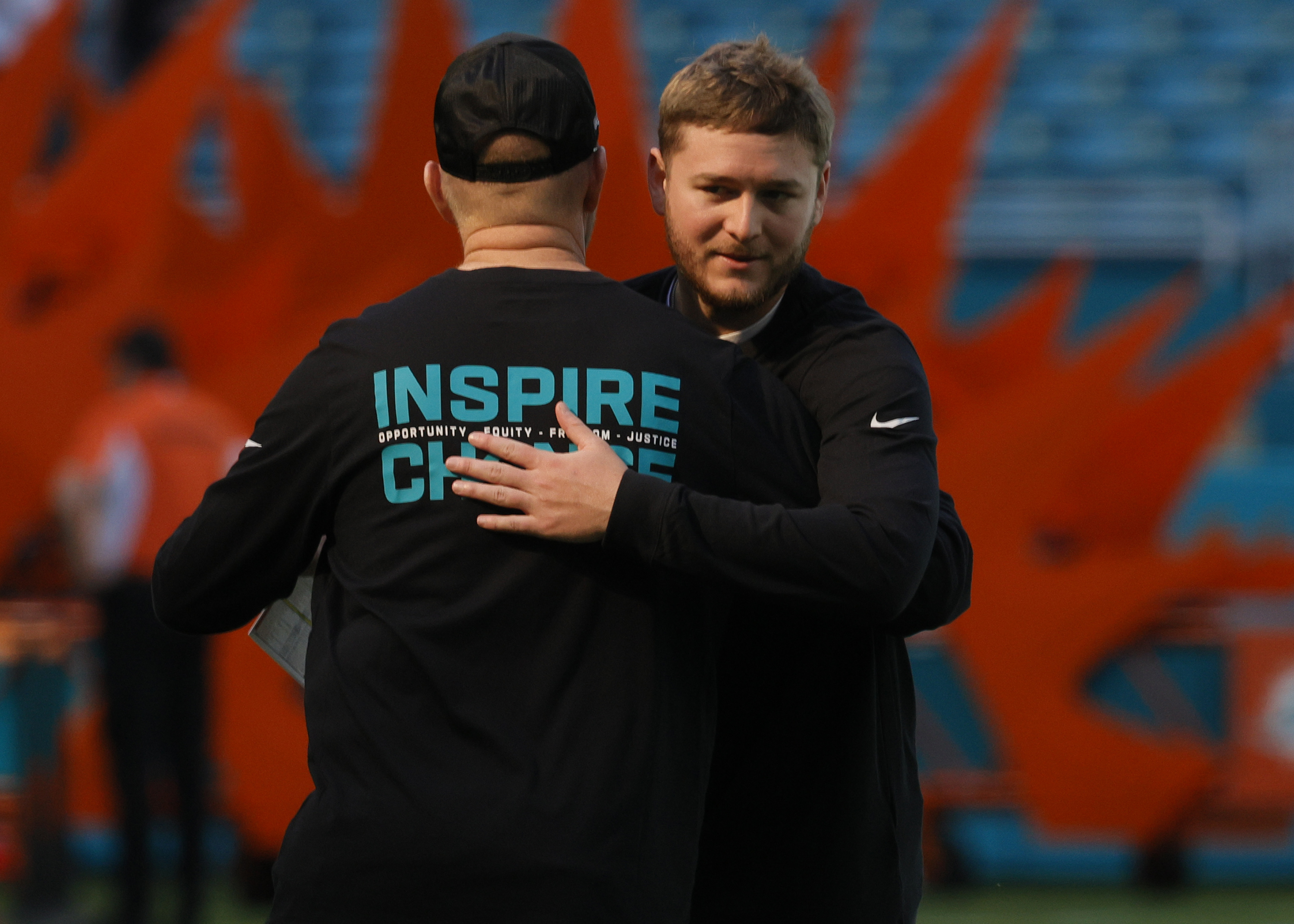 Miami Dolphins quarterback Quinn Ewers (14) embraces quarterbacks coach Darrell...