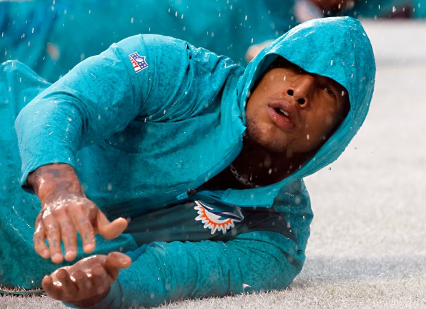 Miami Dolphins tight end Darren Waller stretches in the rain...