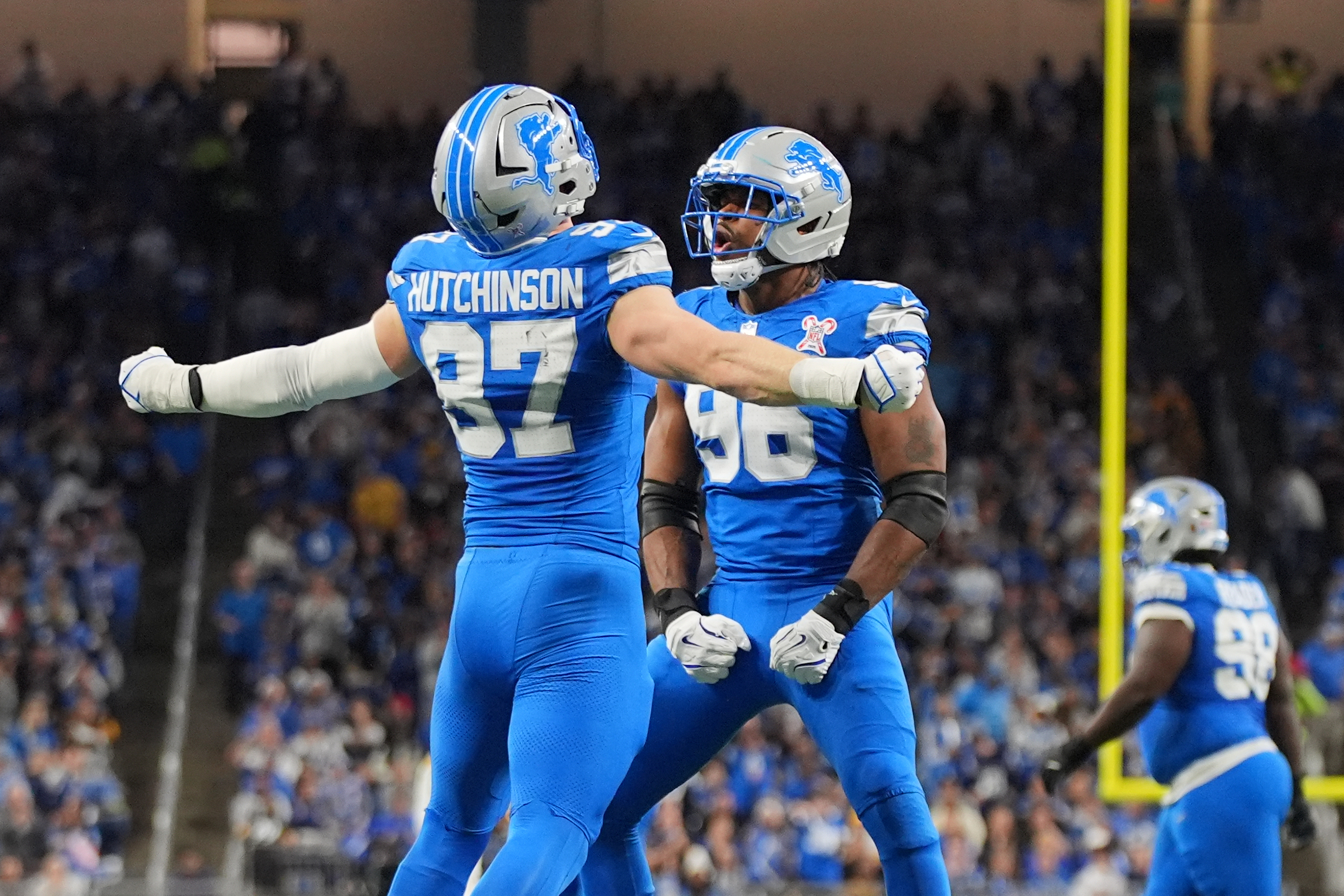 Detroit Lions’ Aidan Hutchinson, left, and Al-Quadin Muhammad react after...